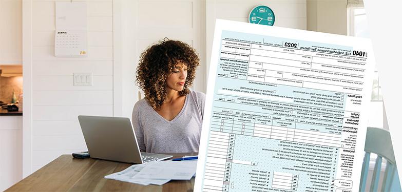 用电脑报税的女人，IRS 1040表格，和美国邮政总局优先邮件信封.
